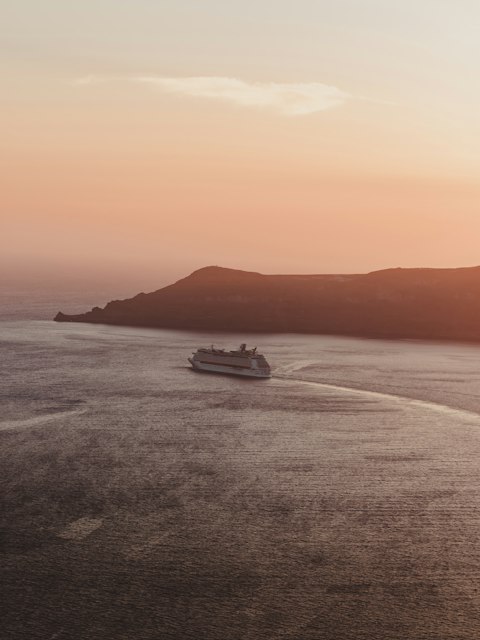Navio de cruzeiro navegando ao pôr do sol